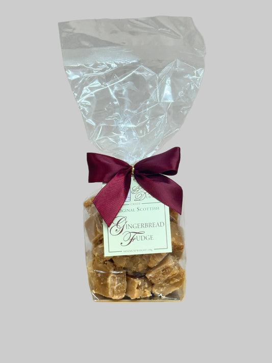 Bag of gingerbread fudge with a red ribbon and label on a light gray background
