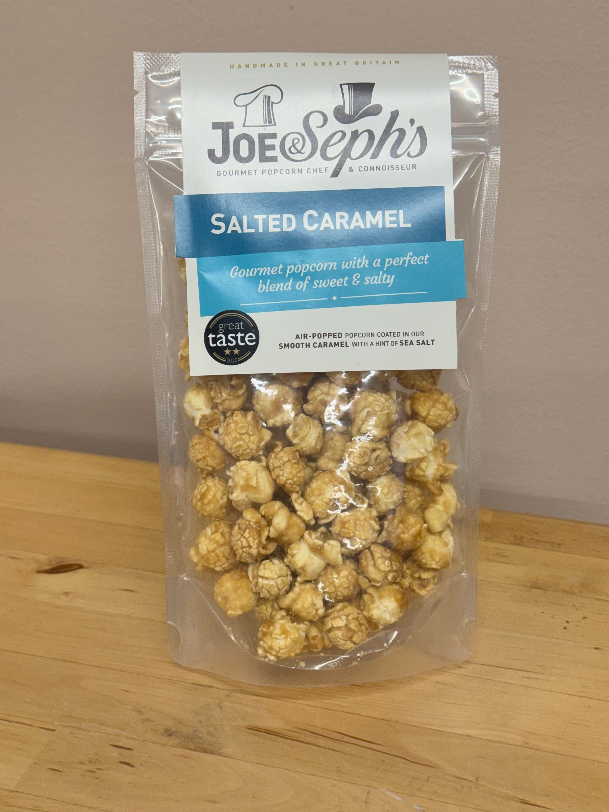 Packaged salted caramel popcorn with Joe Seph's branding on a wooden surface.