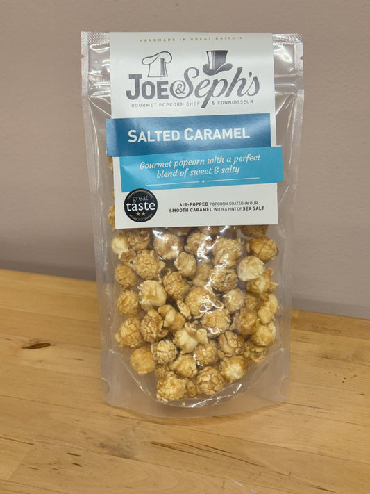 Packaged salted caramel popcorn with Joe Seph's branding on a wooden surface.